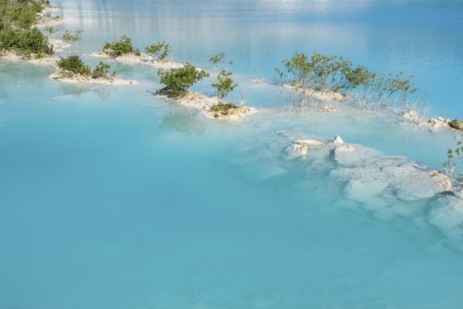 Lagoon in the lake with turquoise water and trees growing on the limestone rocks. Faxe Kalkbrud, Denmark